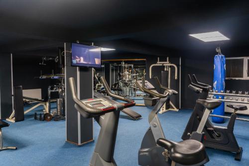 a gym with cardio machines and a flat screen tv at Best Western Plus Lido Hotel in Timişoara