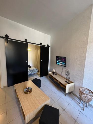 un salon avec une table et une télévision dans l'établissement Le Tarenga-Beziers Centre-Wifi, à Béziers