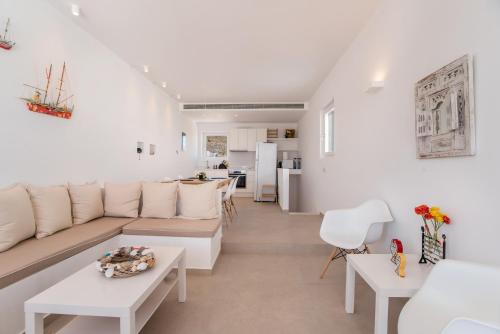 a living room with a couch and a table at Deluxe Maisonette With Private Jacuzzi in Glifades