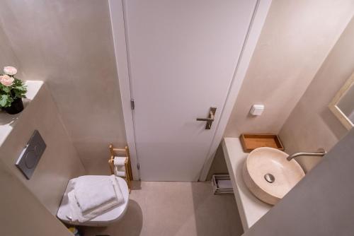 a small bathroom with a toilet and a sink at Deluxe Maisonette With Private Jacuzzi in Glifades