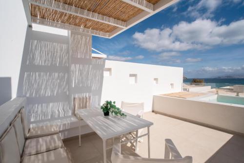 a white balcony with a white table and chairs at Deluxe Maisonette With Private Jacuzzi in Glifades