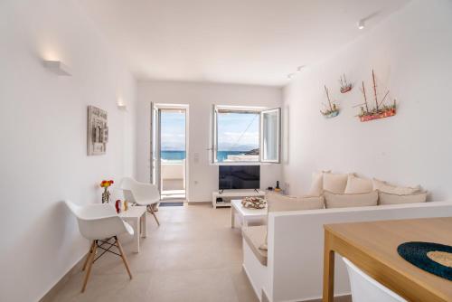 a living room with white furniture and a view of the ocean at Deluxe Maisonette With Private Jacuzzi in Glifades