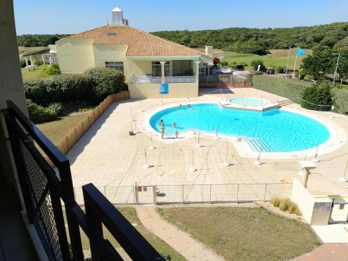 une piscine avec des gens qui jouent dedans dans l'établissement PAMPLEMOUSSE 2 - Appartement avec piscine, vue mer, proche golf, à Saint-Jean-de-Monts