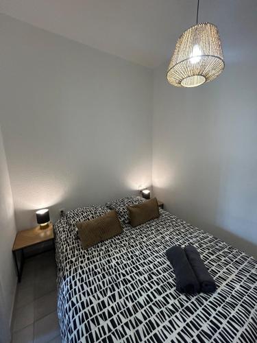 une chambre avec un lit avec une couette noire et blanche dans l'établissement Le Tarenga-Beziers Centre-Wifi, à Béziers