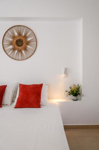 a white bed with red pillows and a mirror at Deluxe Maisonette With Private Jacuzzi in Glifades