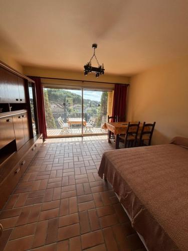 une chambre avec un lit et une table et une grande fenêtre dans l'établissement Les Mercadiers, au Lavandou