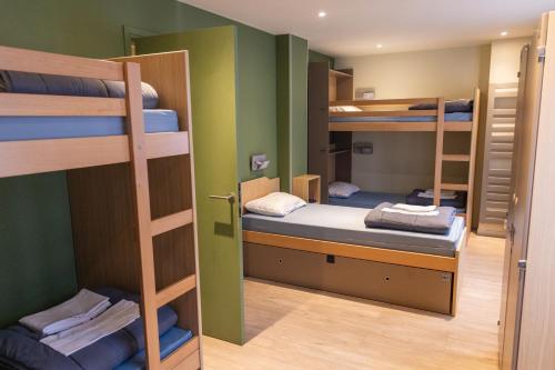 Una habitación con tres literas y un pasillo. en Adveniat Paris, en París