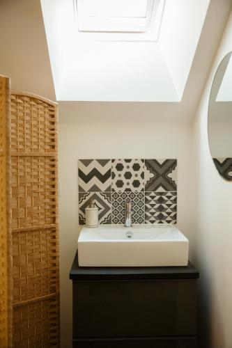 La salle de bains est pourvue d'un lavabo et d'une lucarne. dans l'établissement La Borgnardais - chambres étape tout équipées, à Loutehel