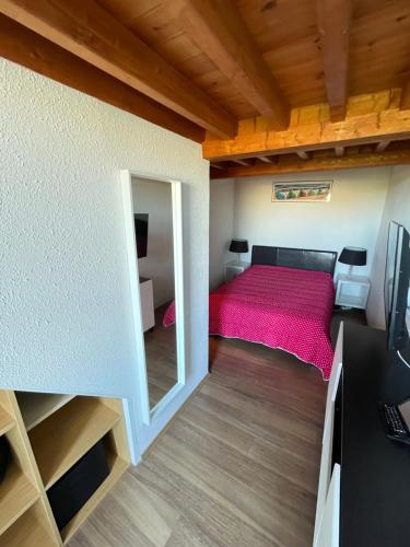 une petite chambre avec un lit et un miroir dans l'établissement Réf 263, Seignosse océan, Villa Patio classée 3 étoiles avec Wifi à 150m de la plage, en bordure de forêt avec place de parking et piscine commune, à Seignosse