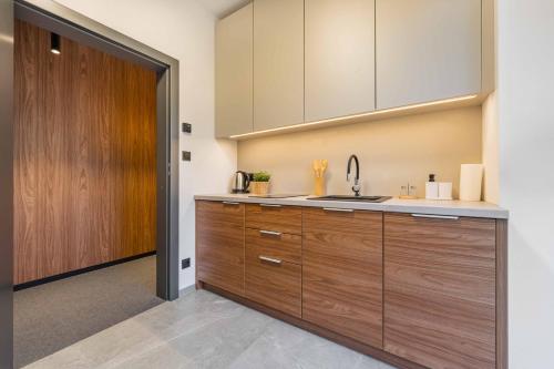 a kitchen with wooden cabinets and a sink at Apartamenty Pod Grojcem - Dream Apart in Żywiec