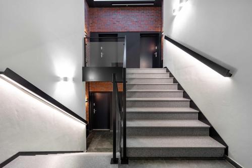 a staircase leading up to a building with a brick wall at Apartamenty Pod Grojcem - Dream Apart in Żywiec