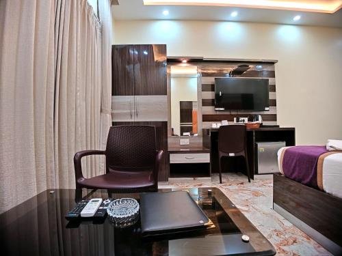 a hotel room with a bed and a desk with a television at Elegant Beach Resort in Mandarmoni