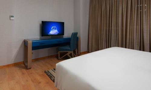 a bedroom with a desk with a television and a chair at Nile Suites Plaza Hotel Apartments in Cairo