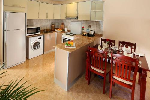 a kitchen with a counter and a table with chairs at Best Western Plus Salmiya in Kuwait