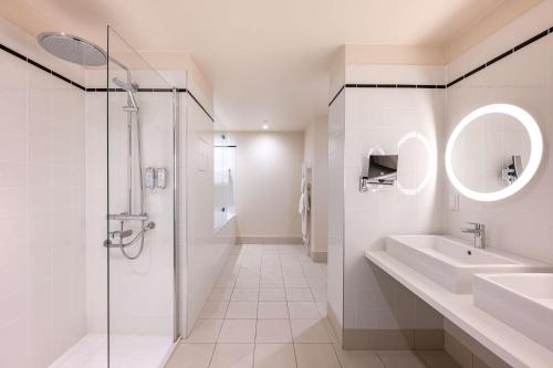 une salle de bain blanche avec un lavabo et une douche dans l'établissement Le Relais de La Malmaison, a member of Radisson Individuals, à Rueil-Malmaison