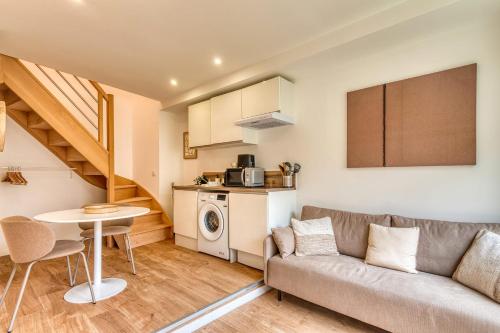 een woonkamer met een bank en een tafel bij L’Epicéa - RDJ duplex proche métrohôpital in Oullins