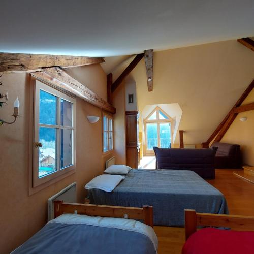 une chambre avec deux lits et une fenêtre dans l'établissement Maison avec jardin 6-12 personnes, proche du lac Annecy montagnes, à La Balme-de-Thuy