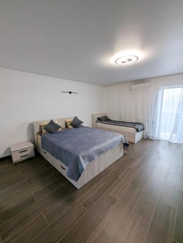 a bedroom with two beds and a wooden floor at Ізумруд in Chop