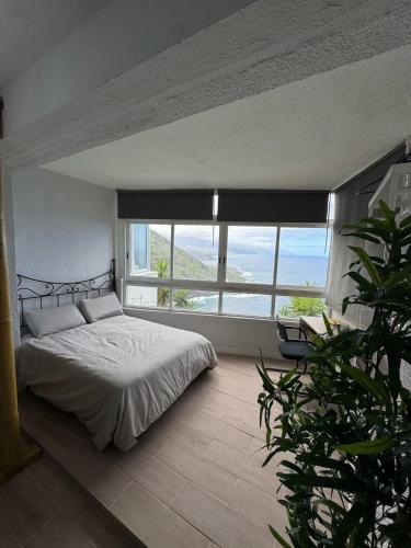a bedroom with a bed and a large window at Ocean Panorama in Puntillo del Sol
