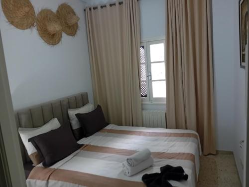 a bedroom with a bed with two towels on it at heart of marsa beach in Douar el Hafey