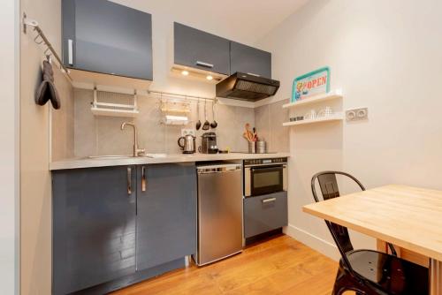 une cuisine avec des appareils en acier inoxydable et une table en bois dans l'établissement Le Boubée - Studio proche gare, à Toulouse