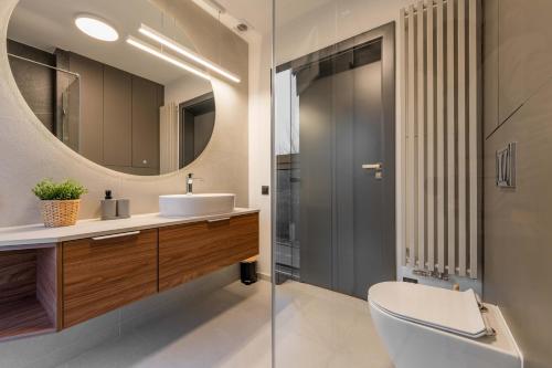 a bathroom with a toilet and a sink and a mirror at Apartamenty Pod Grojcem - Dream Apart in Żywiec