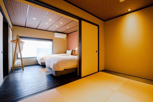a bedroom with yellow walls and a bed and a mirror at Kyoya Nobuhiro Rakutyu in Kyoto