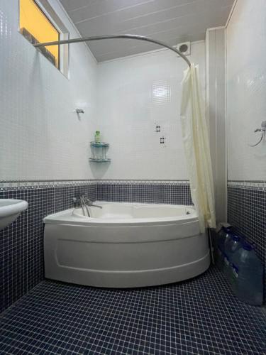 a bathroom with a bath tub and a sink at Cozy apartment 2 in Samarkand