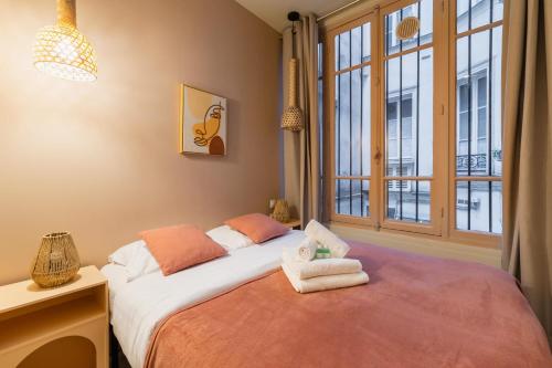 une chambre avec un lit et une fenêtre dans l'établissement Charmant appartement moderne haut marais - 4P, à Paris