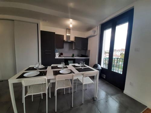 モントーバンにあるLe beau T3 Fonneuve clim parking facileの部屋にテーブルと椅子のあるキッチン