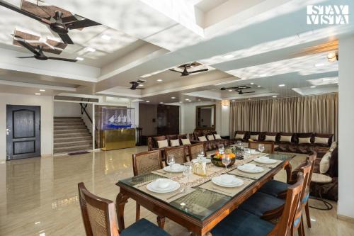a dining room with a long table and chairs at StayVista at Auburn Dusk with BBQ & Pool in Panchgani