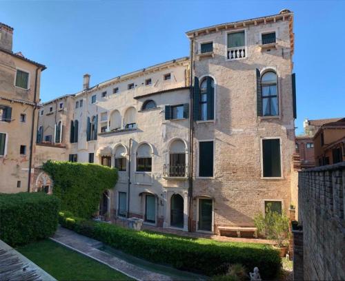 an old brick building with a bench in front of it at Palazzo Contarini Della Porta Di Ferro in Venice