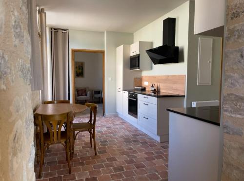 une cuisine avec une table et des chaises dans une pièce dans l'établissement Gîte de La Baumée, à Hiesville