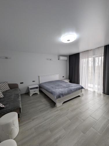 a bedroom with a bed and a couch at Ізумруд in Chop