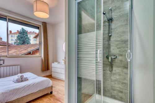 La salle de bains est pourvue d'une douche en verre et d'un lit. dans l'établissement L’Epicéa - RDJ duplex proche métrohôpital, à Oullins