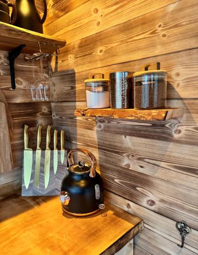 a tea kettle on a wooden table with utensils at Heart of Nature - Luksus Glamping & Spa in Nørre Hvalsø