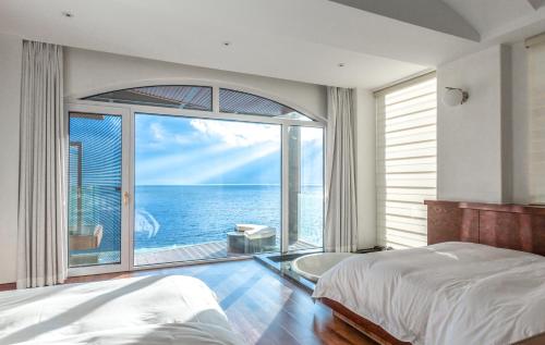 a bedroom with a view of the ocean at Dali Mermaid Seascape Resort Hotel in Dali
