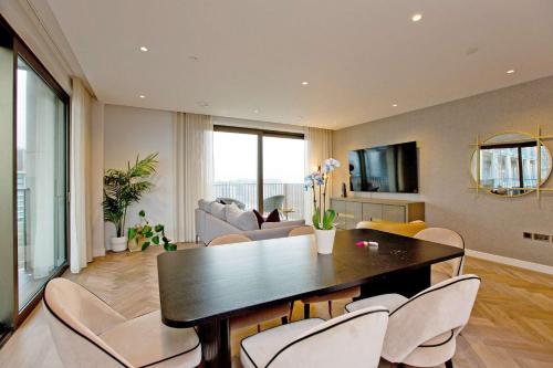 a living room with a dining table and chairs at Luxury Living with City Views with Pool and Gym AC in London