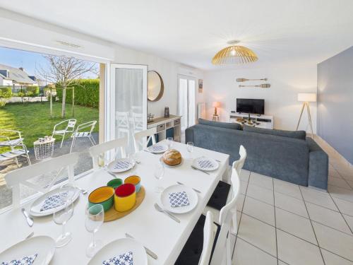 une salle à manger et un salon avec une table et des chaises blanches dans l'établissement Maison familiale pour 7 proche de la mer, à Tréffiagat