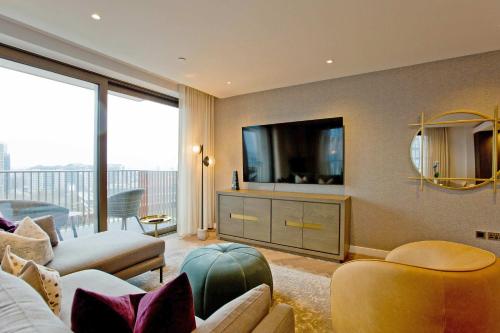 a living room with a couch and a tv at Luxury Living with City Views with Pool and Gym AC in London