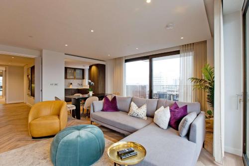 a living room with a gray couch and purple pillows at Luxury Living with City Views with Pool and Gym AC in London