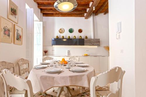 een witte eetkamer met een tafel en stoelen bij Genteel Home Mateos Gago Terrace VI in Sevilla