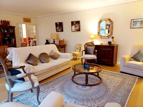 a living room with a couch and a table at Splendide appartement soleil terrasse in Sceaux