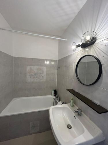 une salle de bain avec un lavabo, une baignoire et un miroir dans l'établissement Foch 7-Proche Allée Paul Riquet-wifi-tv connectée, à Béziers