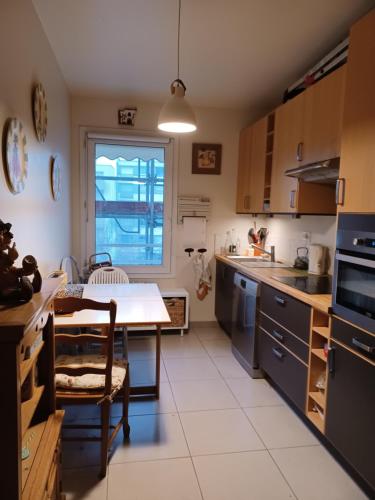 une cuisine avec une table et une salle à manger dans l'établissement Splendide appartement soleil terrasse, à Sceaux