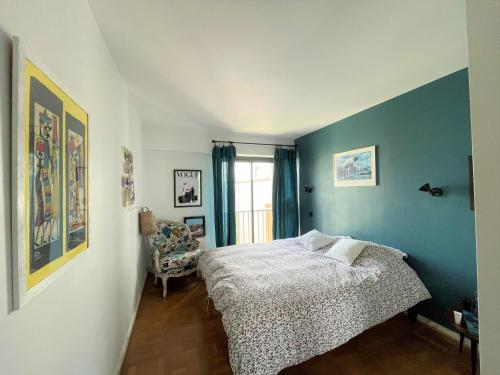 une chambre avec un lit et un mur bleu dans l'établissement Superbe appartement à St Raphaël, tout à pied, à Saint-Raphaël