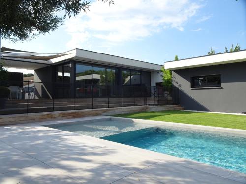 une piscine devant une maison dans l'établissement L'Ecrin Contemporain, à Nages-et-Solorgues