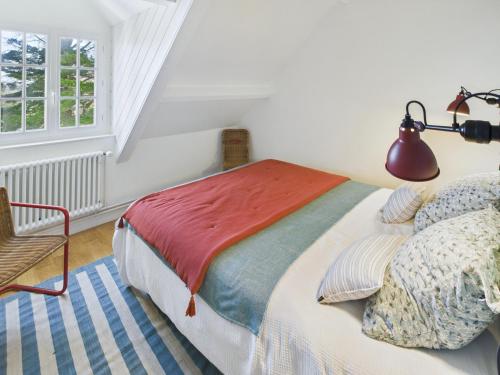 a bedroom with a bed and a lamp and a chair at Maison pour 8 - Piscine chauffée - 800m de la plage in Penmarcʼh