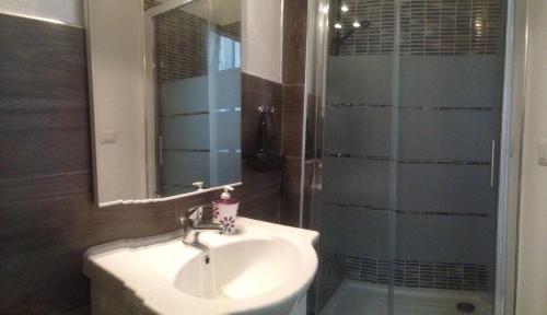 a bathroom with a sink and a shower with a mirror at B&B Maison Rosetta IUN-E4948 in Nuoro