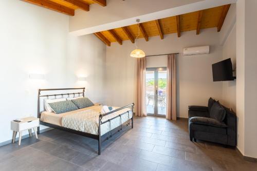 a bedroom with a bed and a chair and a tv at Petrino Serene Studios in Kakóvatos